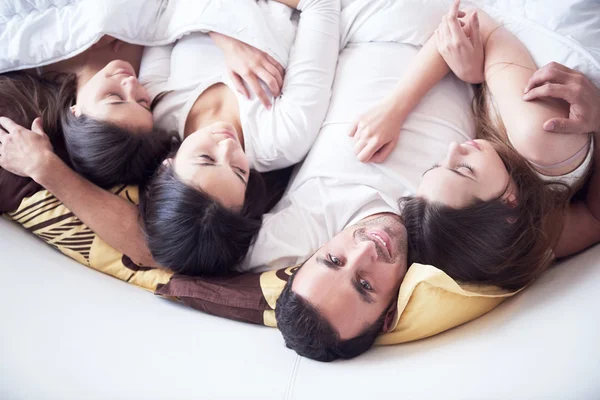 Knappe man in bed met drie mooie vrouwen — Stockfoto