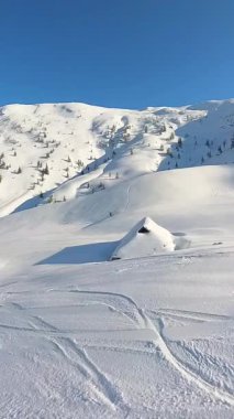Serbest kayağın heyecan verici özgürlüğünü tek başına yaşayan bir maceraperest olarak görkemli bir karlı dağda el değmemiş, el değmemiş bir tozu yontarak yaşayın. Kış sporları için harika bir mavi gökyüzü.