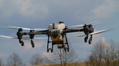 Gelişmiş bir tarımsal İHA otomatik olarak hava püskürtüyor, budanmış meyve ağaçlarının üzerine ince bir ekin koruma sisi salıyor, akıllı tarım teknolojisi ve hassas tarımı sergiliyor.