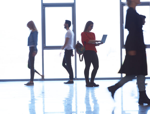 student girl standing with laptop, people group passing by