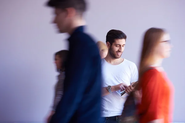 Estudiante trabajando en la tableta, grupo de personas que pasa por — Foto de Stock