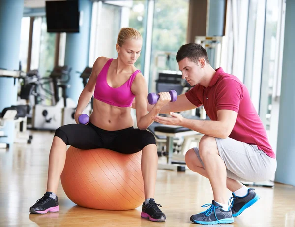 Jeune femme sportive avec entraîneur haltères d'exercice levage — Photo