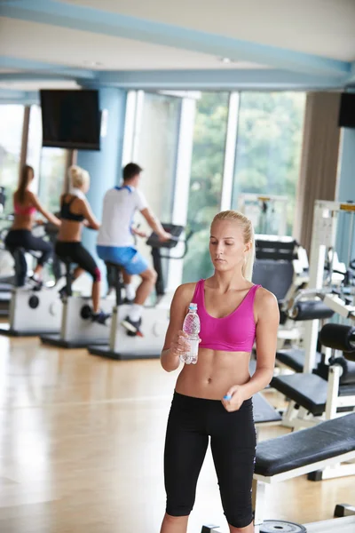 Woman in fitness gym drinking water — Stock Photo, Image