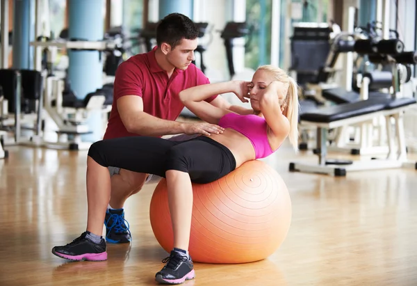 Mujer joven y deportiva con ejercicio de entrenador en gimnasio de fitness —  Fotos de Stock