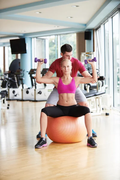 Jeune femme sportive avec entraîneur haltères d'exercice levage — Photo