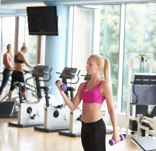 Levantando pesas y trabajando en sus bíceps en un gimnasio — Foto de Stock