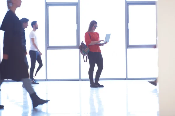 Studente ragazza in piedi con computer portatile, gruppo di persone di passaggio — Foto Stock