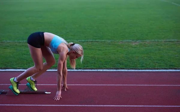 Vrouw sprinter verlaten startblokken — Stockfoto