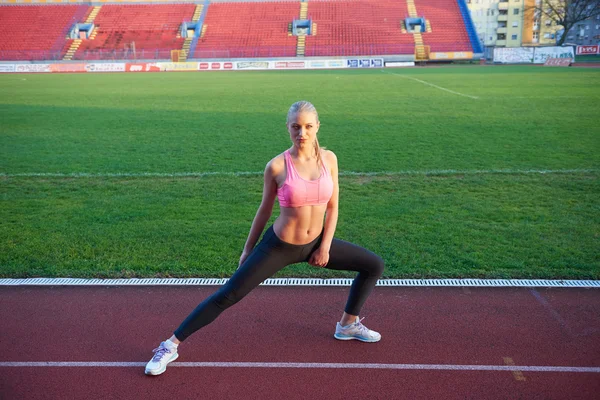 Mulher esportiva na pista de corrida atlética — Fotografia de Stock