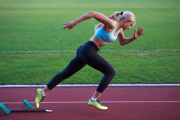 Kvinde sprinter forlader startblokkene - Stock-foto