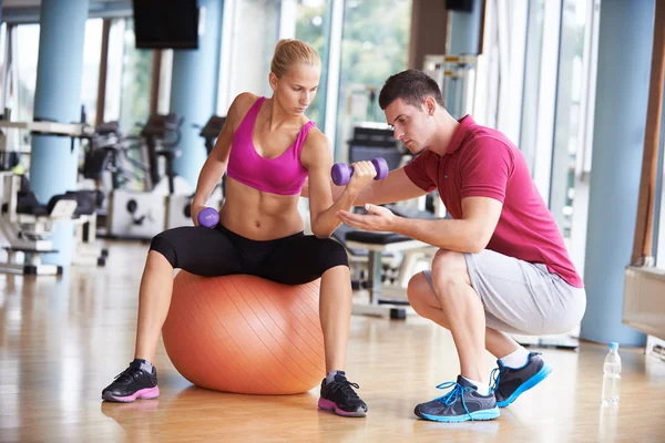 Femme avec entraîneur haltères d'exercice levage — Photo