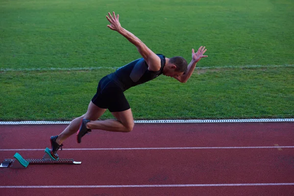 Athletic man start on track Stock Photo