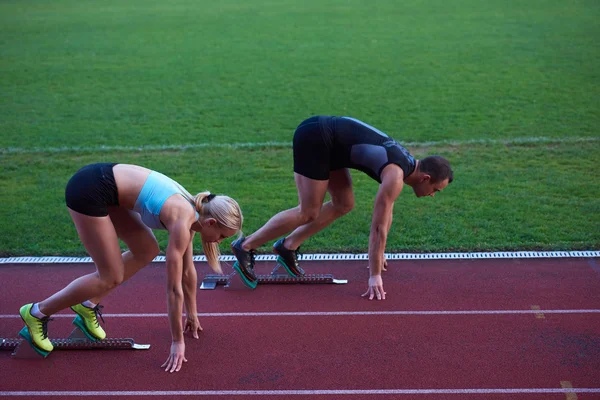 Grupo de mujeres corriendo en pista de atletismo desde el principio — Foto de Stock