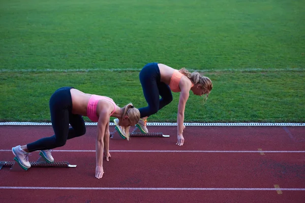 Mujeres corriendo en pista de atletismo desde el principio —  Fotos de Stock