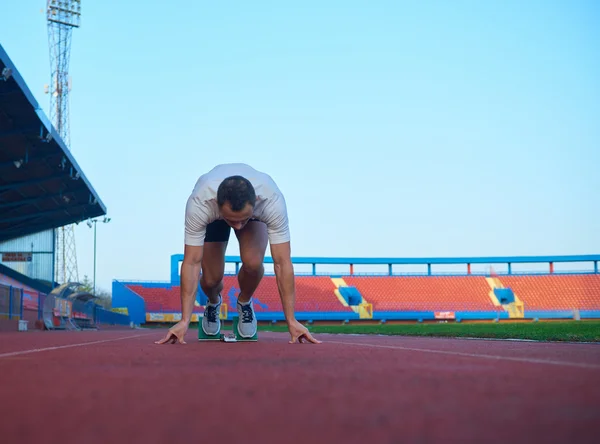 Atletische man start op de rails — Stockfoto