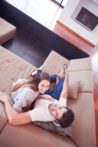 Jovem casal assistindo tv em casa — Fotografia de Stock