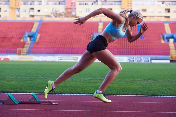 Woman  sprinter leaving starting blocks — Stock Photo, Image