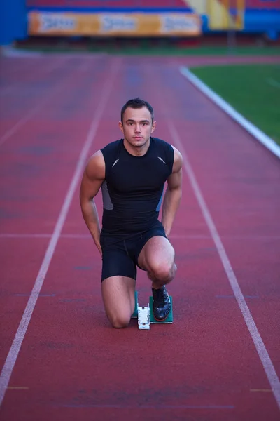 Atletisk mand starter på sporet - Stock-foto