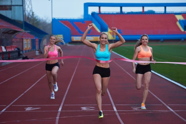 Atlet femei grup care rulează pe pista de curse de atletism — Fotografie, imagine de stoc