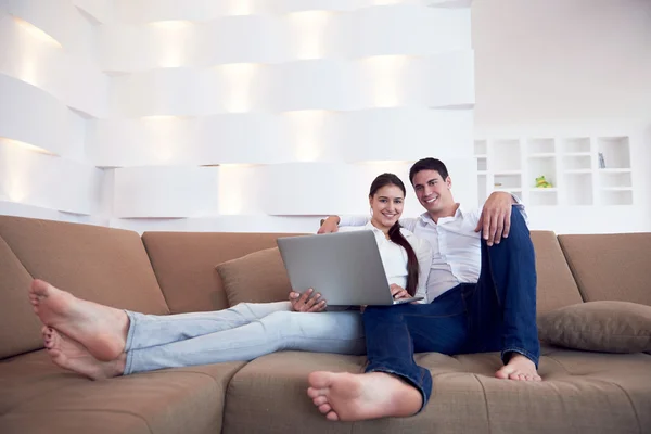 Jeune couple détendu travaillant sur ordinateur portable à la maison — Photo
