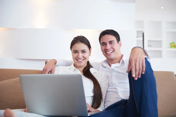 Ontspannen jonge paar werken op laptopcomputer thuis — Stockfoto