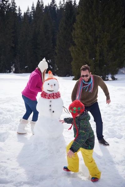 Feliz familia edificio muñeco de nieve —  Fotos de Stock