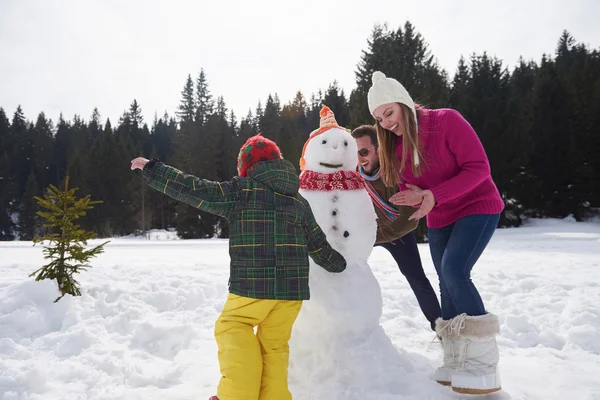 Feliz familia edificio muñeco de nieve —  Fotos de Stock