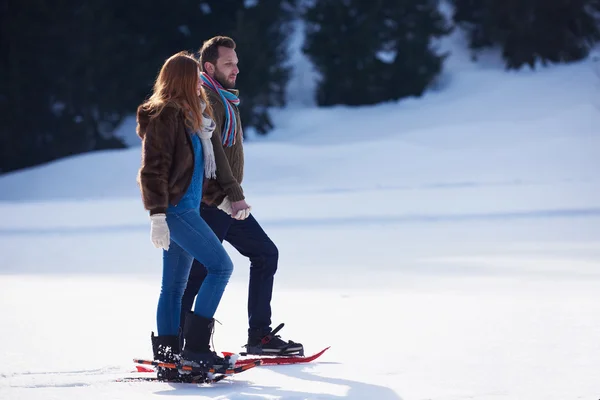 Couple having fun and walking in snow shoes — Stock Photo, Image