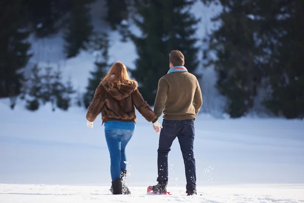 Casal se divertindo e andando em sapatos de neve — Fotografia de Stock