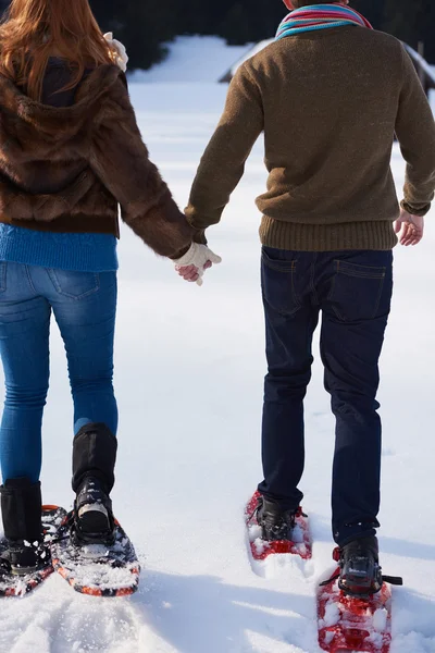Eğleniyor ve kar ayakkabı yürürken bir çift — Stok fotoğraf