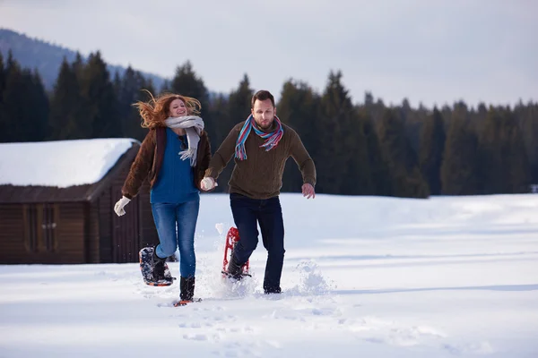 Paar beim Spazierengehen in Schneeschuhen — Stockfoto