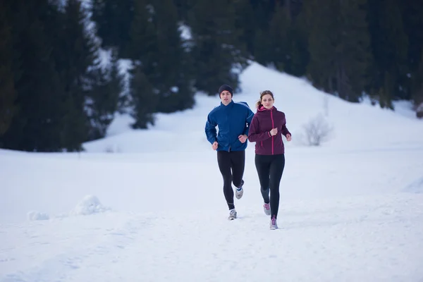 Paar joggt draußen auf Schnee — Stockfoto