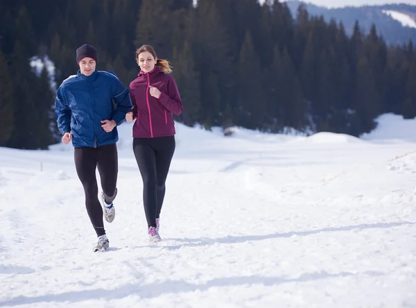 Paar joggt draußen auf Schnee — Stockfoto