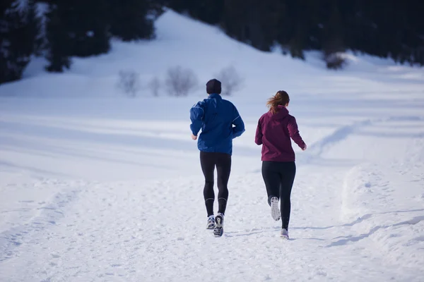 Пара бег на улице на снегу — стоковое фото