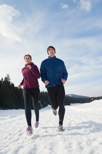 Paar joggt draußen auf Schnee — Stockfoto