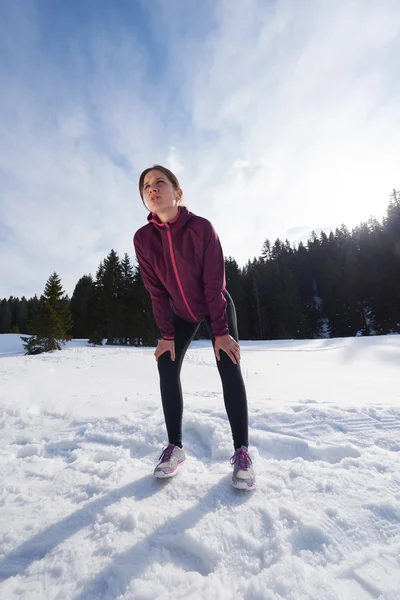 Jonge vrouw joggen buiten op sneeuw in bos — Stockfoto