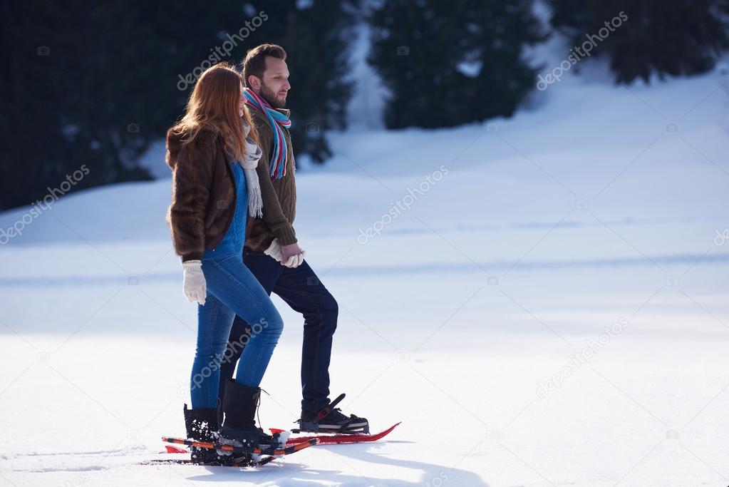 couple having fun and walking in snow shoes