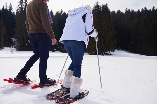 Casal se divertindo e andando em sapatos de neve — Fotografia de Stock