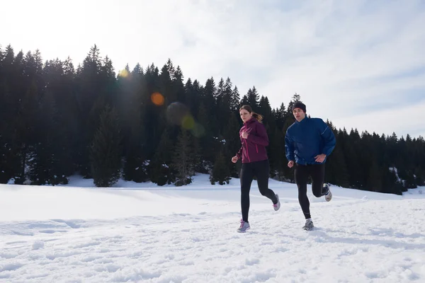 Paar joggt draußen auf Schnee — Stockfoto