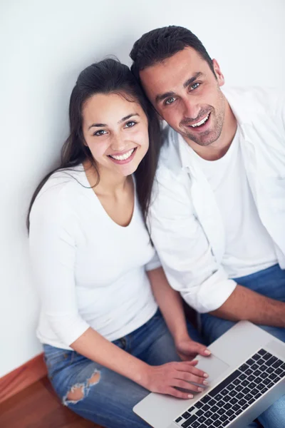Avslappnad ungt par som arbetar på bärbar dator hemma — Stockfoto