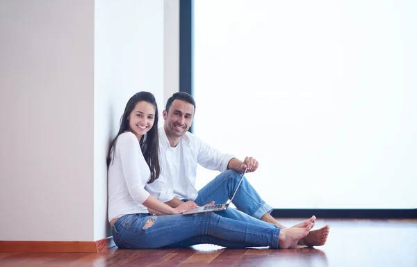 Relaxado jovem casal trabalhando no computador portátil em casa — Fotografia de Stock