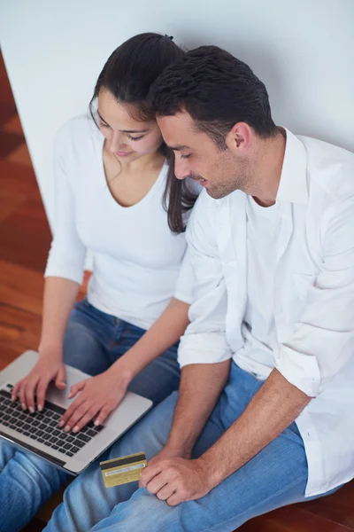 Relaxado jovem casal trabalhando no computador portátil em casa — Fotografia de Stock