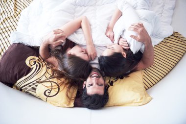 üç güzel kadınlarla yatakta yakışıklı adam