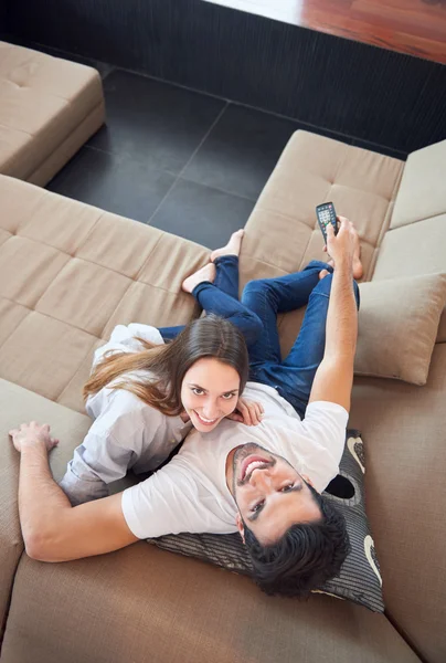 Jeune couple regarder la télévision à la maison — Photo