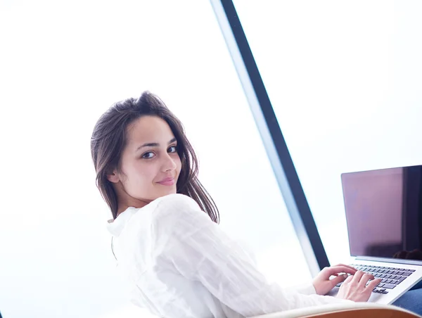 Ontspannen jonge vrouw thuis werken op laptopcomputer — Stockfoto