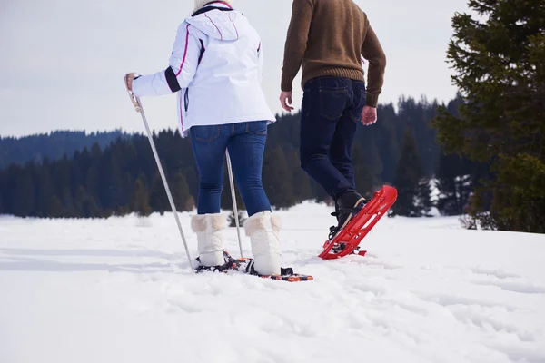 Пара развлекается и ходит в снежных туфлях — стоковое фото
