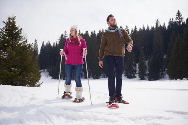 Ζευγάρι, τη διασκέδαση και το περπάτημα στα παπούτσια χιόνι — Φωτογραφία Αρχείου