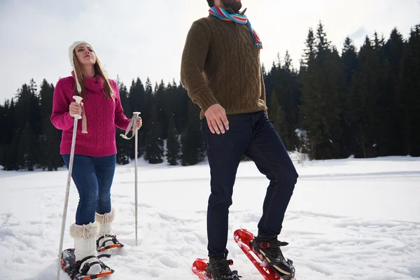 Paar beim Spazierengehen in Schneeschuhen — Stockfoto