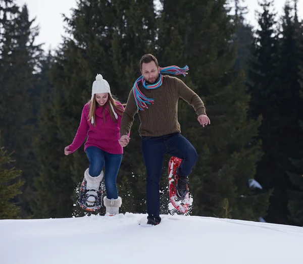 Couple having fun and walking in snow shoes — Stock Photo, Image