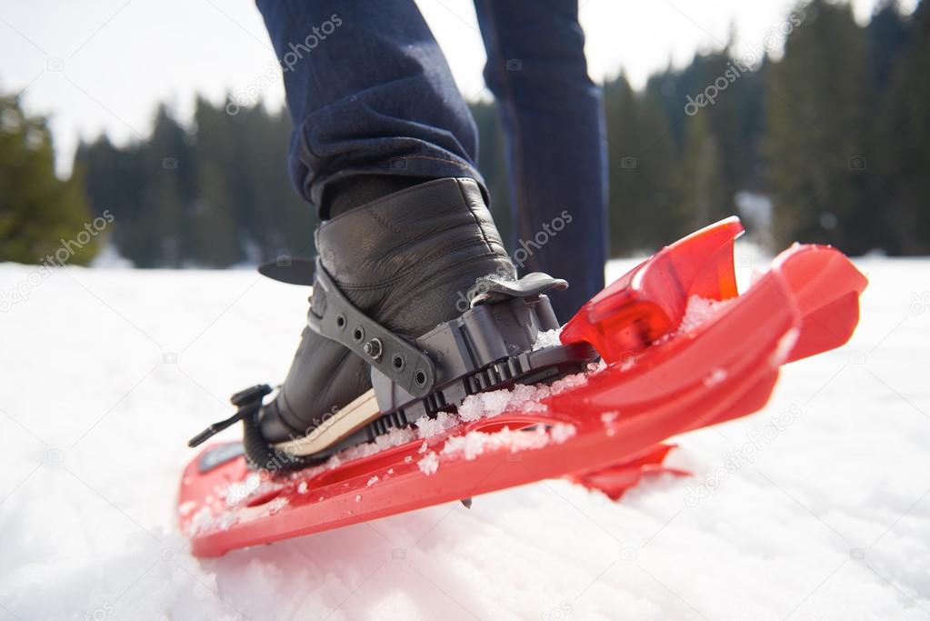 man having fun and walking in snow shoes